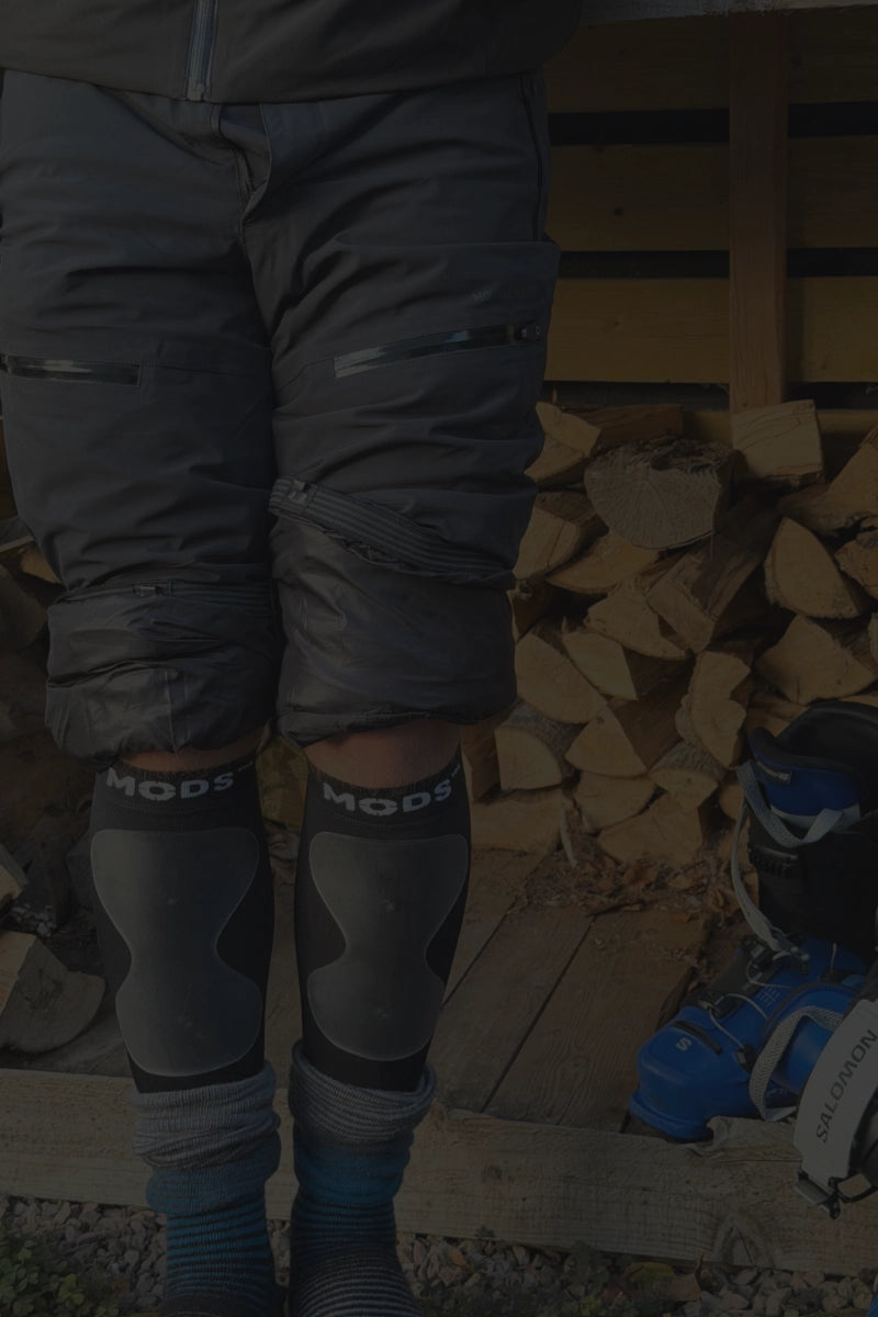 Skier wearing MODS protective shin sleeves with raised gel padding, designed to help reduce ski boot pressure, protect the shins and improve comfort while skiing.