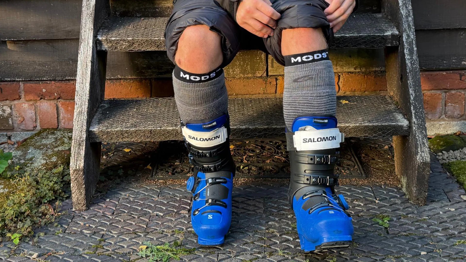 Skier wearing MODS shin protection sleeves with Salomon ski boots, providing targeted gel cushioning to help reduce ski boot pressure, shin discomfort and rubbing on the slopes.