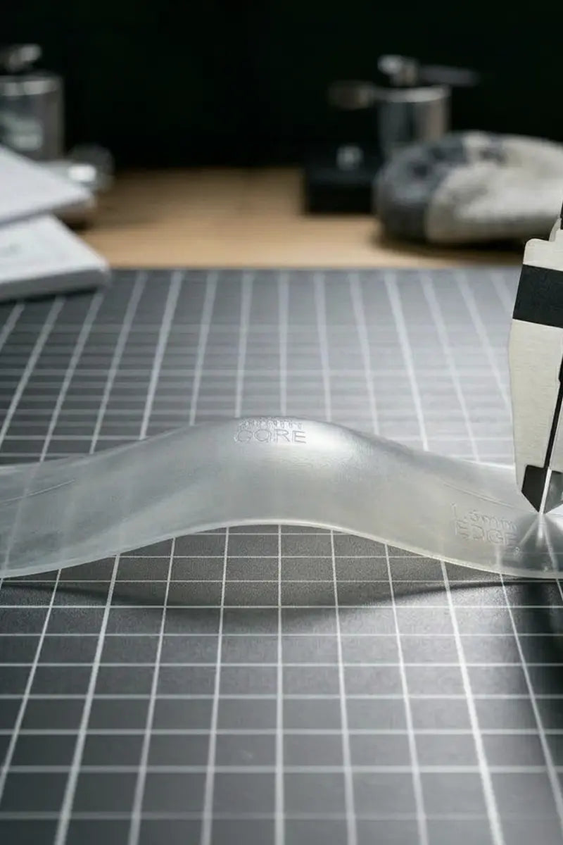 Transparent MODS ski exoskeleton component being measured during prototype testing.