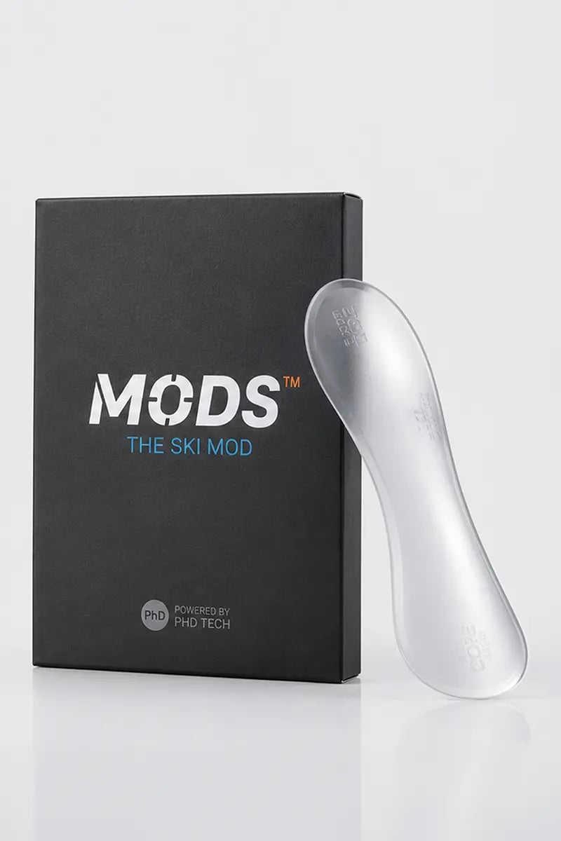 Transparent MODS ski support component displayed beside its black branded packaging.