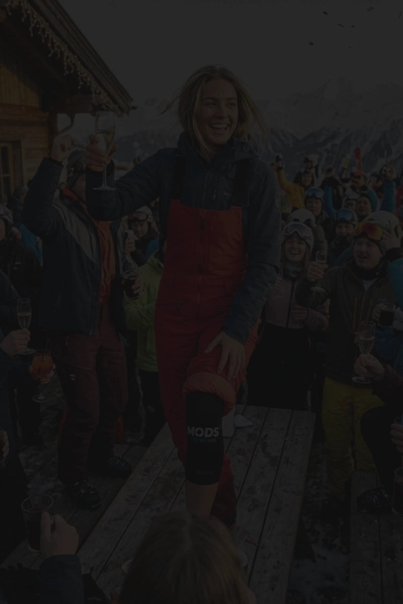 Skier celebrating at an après-ski event while wearing the MODS ski knee support system.