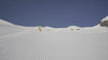 Skier descending a groomed mountain slope during a MODS skiing leg support demonstration.